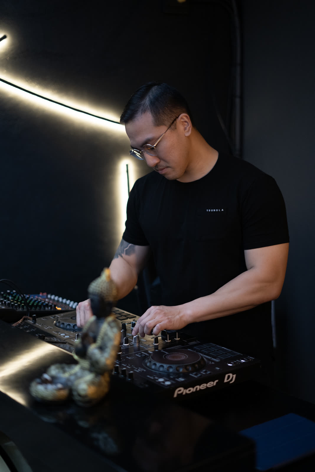 Sean Chi at the Pioneer decks under dark club lighting